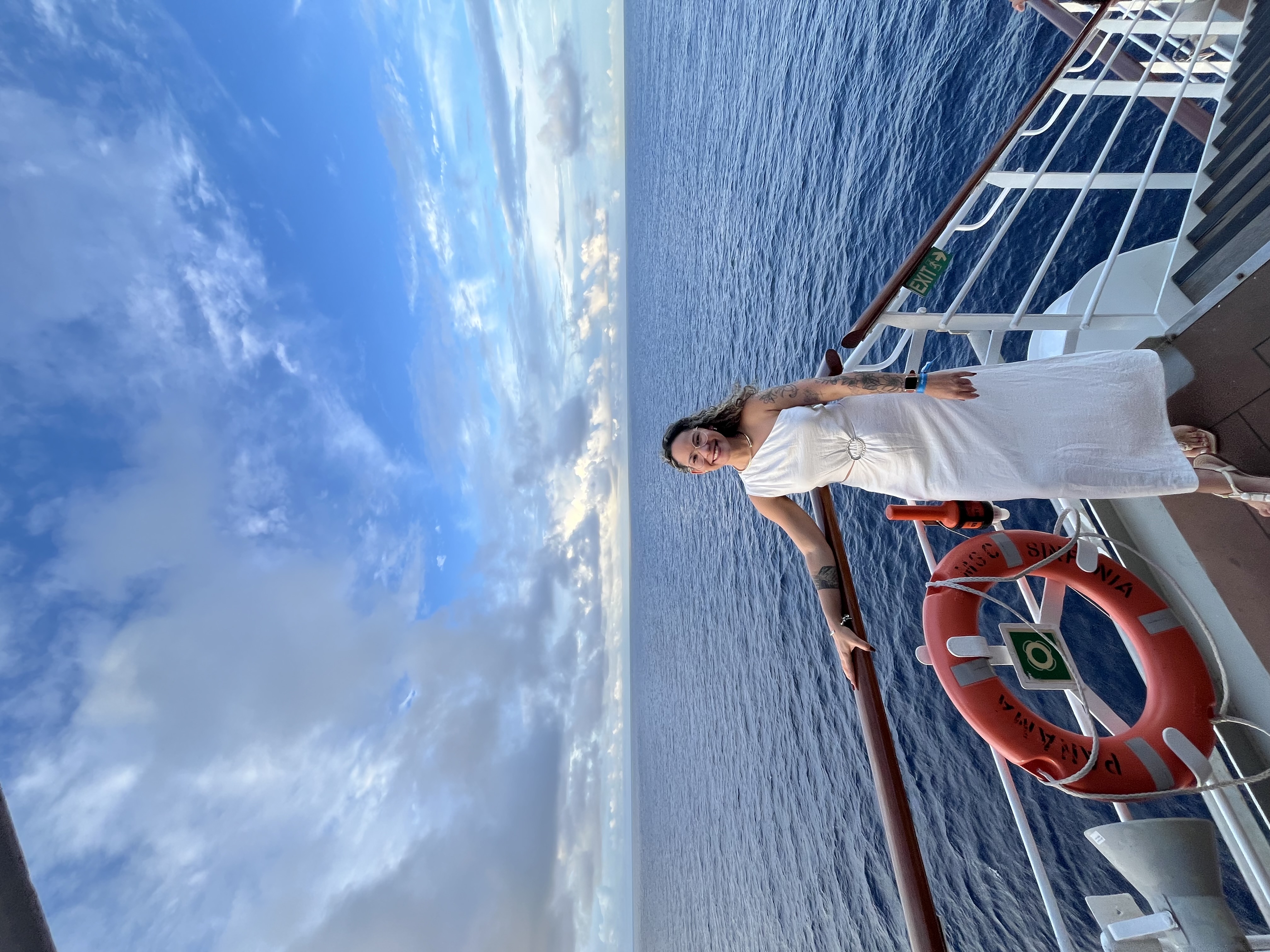 Vivian em um navio, com o mar ao fundo